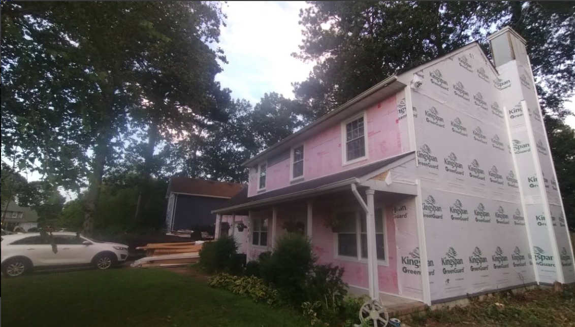 Home wrapped in insulation board during an exterior renovation