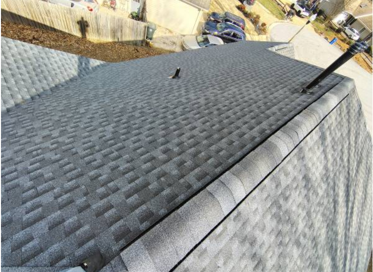Close view of new roof shingles and a vent pipe