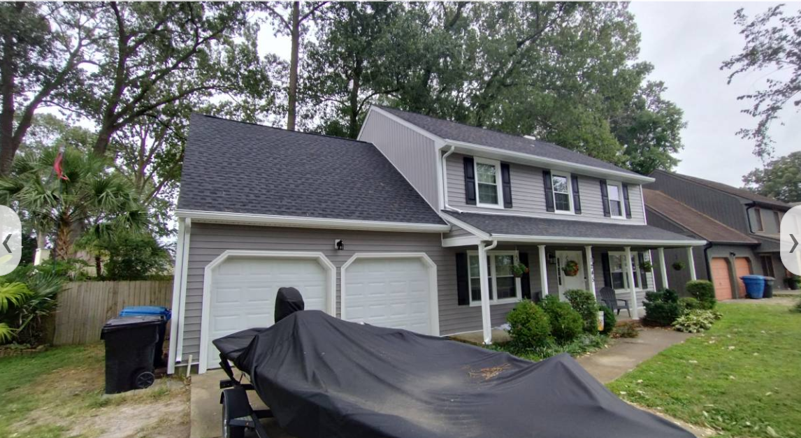 Front of a home with two-car garage, new roof, siding and gutters