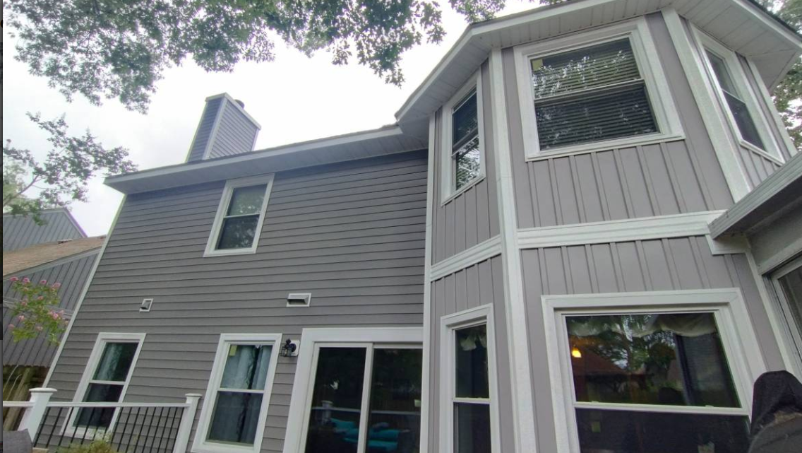 Two-story home with new siding and white window trim